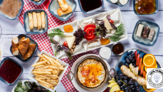 A table with all kinds of food spread across it - fresh fruits and veggies, egg rolls, cheese, french fries, baked good, jams, and more.