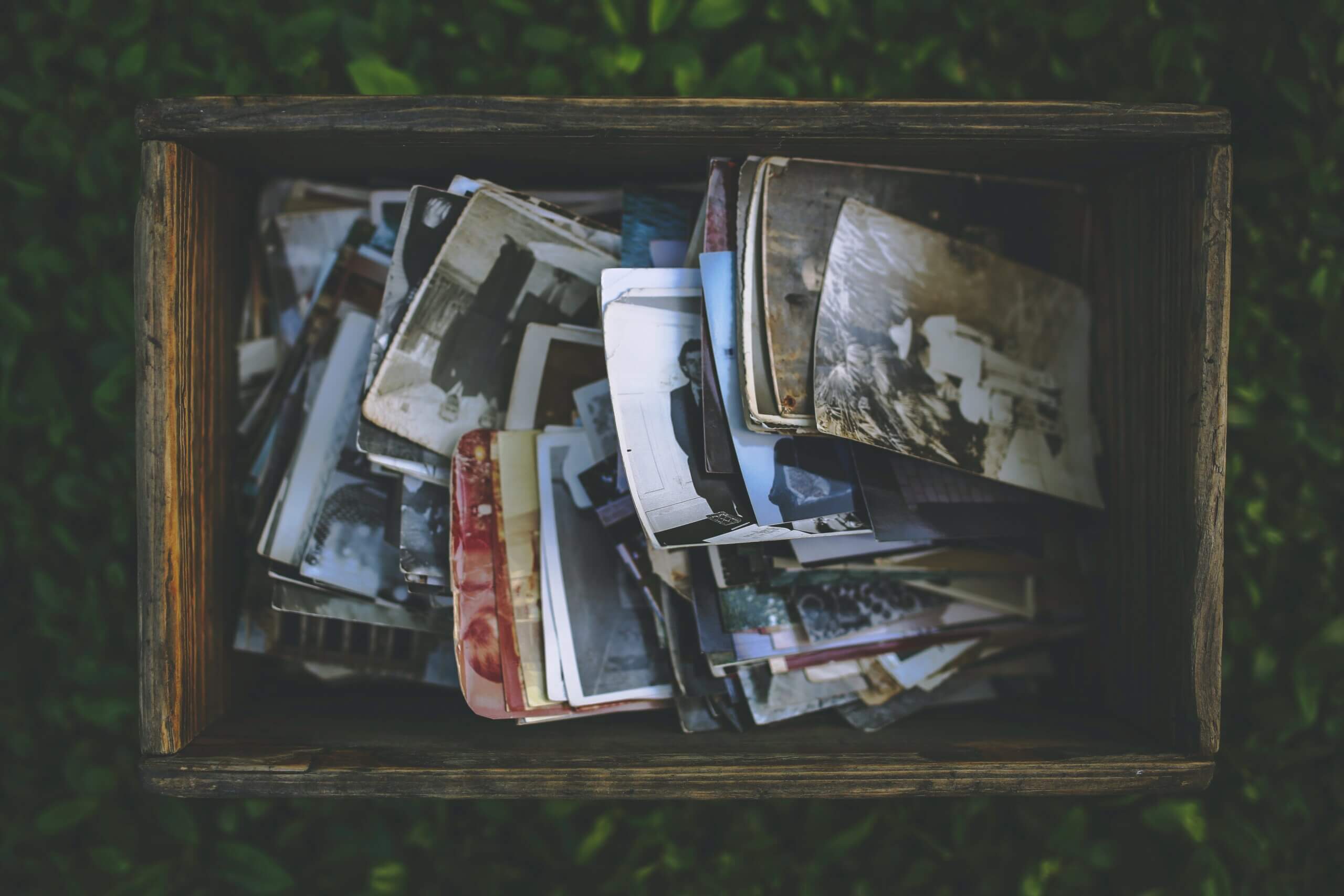 Wooden box on grass filled with antique pictures